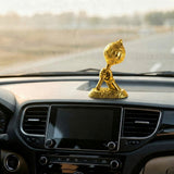 Gold car dashboard ornament on a car's dashboard.