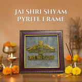Decorative frame with 'JAI SHRI SHYAM' text on a wooden surface with flowers and candles.