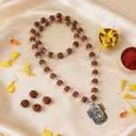 Meditative necklace with rudraksha beads and silver pendant .