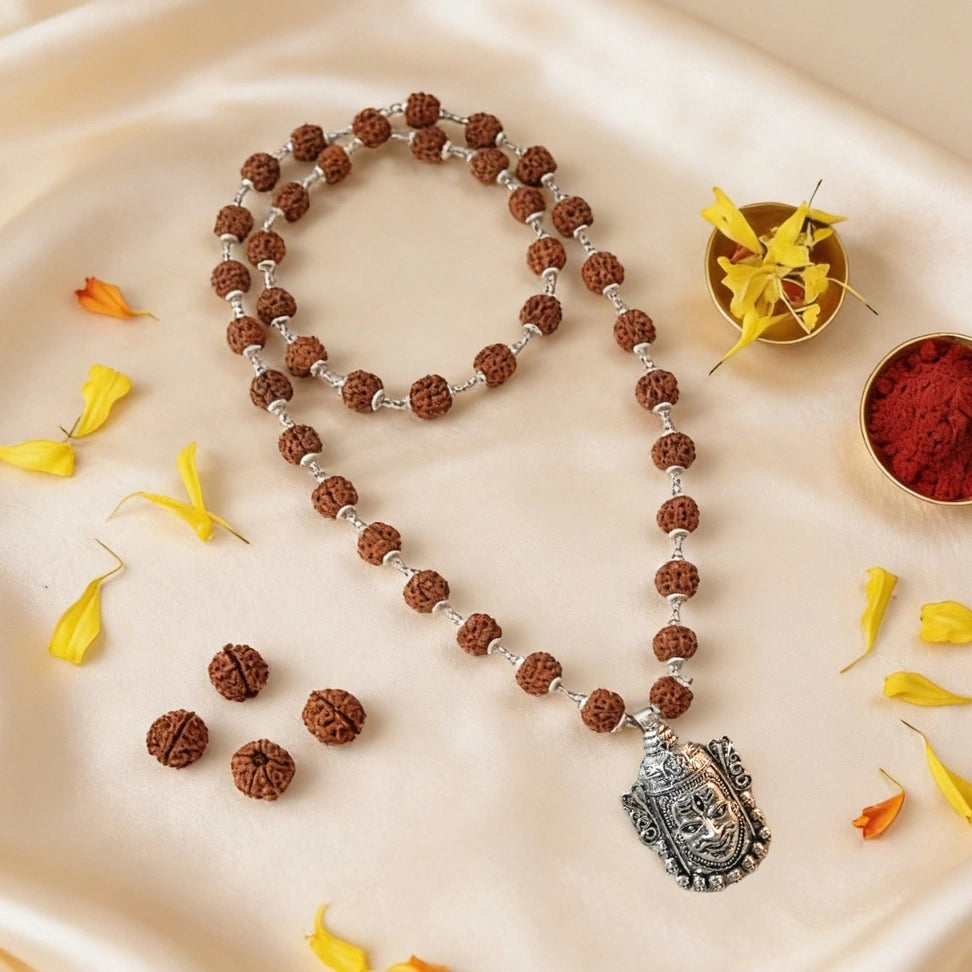 Meditative necklace with rudraksha beads and silver pendant .
