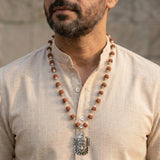 Man wearing a beaded necklace.