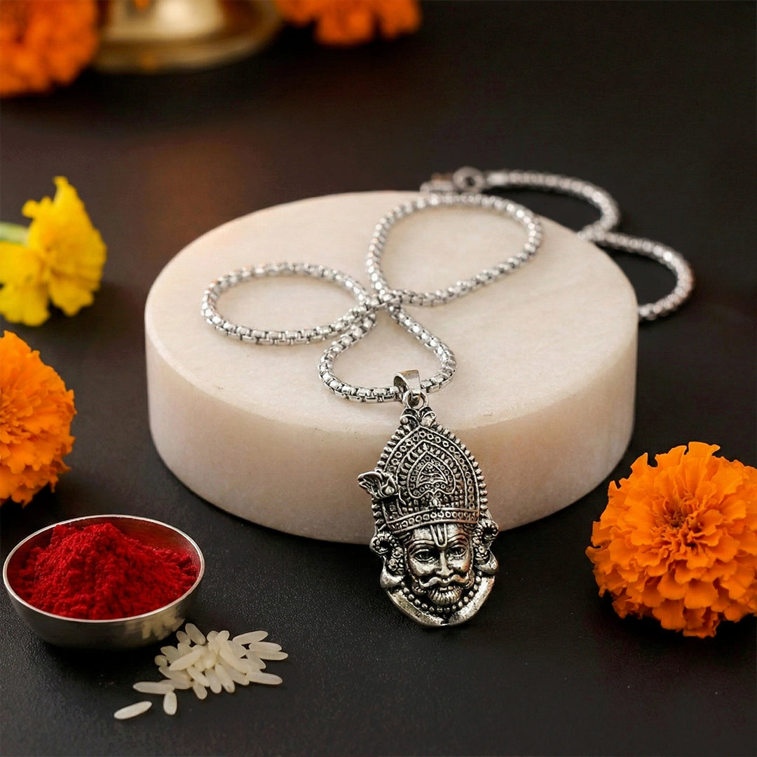 Silver necklace with a detailed pendant on a dark surface.