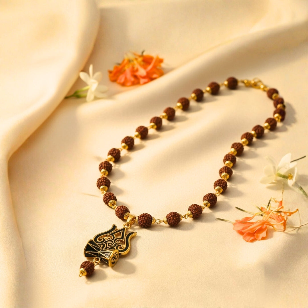 Necklace with brown and gold beads on a beige fabric background with flowers.
