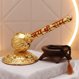 Gold-colored mace with red text on a white surface