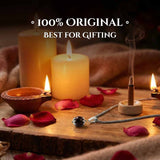 Candle, incense stick, and necklace on a wooden surface.