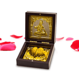 Decorative box with gold figurine and carvings on a white background.