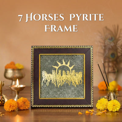 Framed artwork with '7 Horses Pyrite' design on a decorative table with flowers and candles.