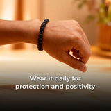 Hand wearing a black beaded bracelet.