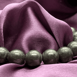 Green beads on a purple fabric background