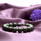 Green beaded bracelet on a purple fabric background