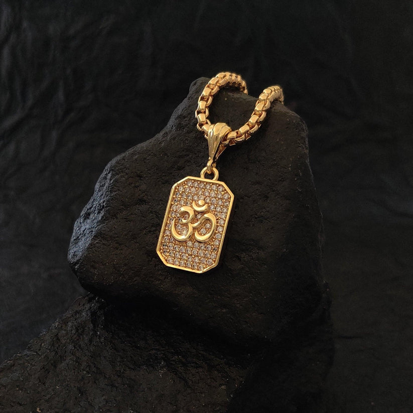 Gold pendant with a symbol on a dark stone surface