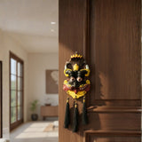 Decorative mask with tassels hanging on a wooden door