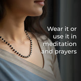Person wearing a beaded necklace with text about.
