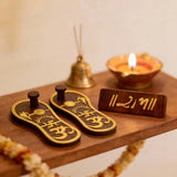 Wooden sandals with gold designs and a small wooden board.