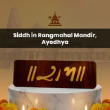 Wooden plaque with numbers on a marble base against a blurred temple.