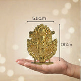 Gold decorative item held in a hand with measurements indicated